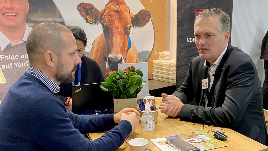 Photo of Diego Galli and Udo Carsensen sitting by a table talking.